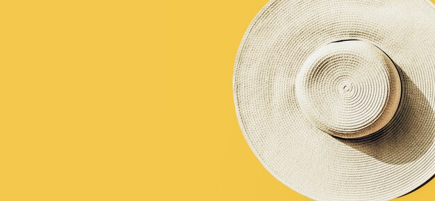 Соломенная шляпа на ярко-желтом солнечном фоне