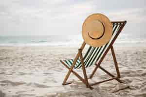 Foto gratuita cappello di paglia continuava a spiaggia sedia vuota