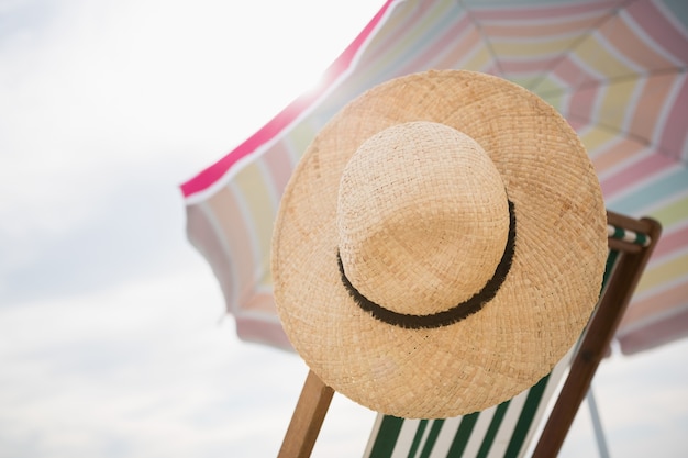 Free photo straw hat kept on empty beach chair