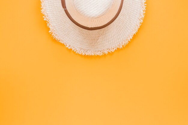 Straw hat on yellow table