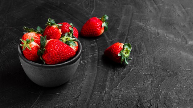 Strawberries in bowl on black table