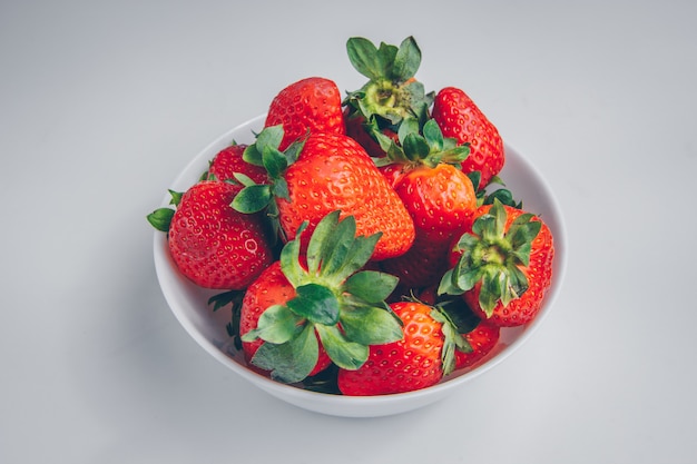 Strawberries in a bowl on a white background. high angle view.