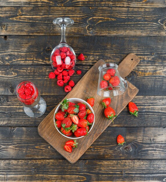 Strawberries in bowl with raspberries in glasses