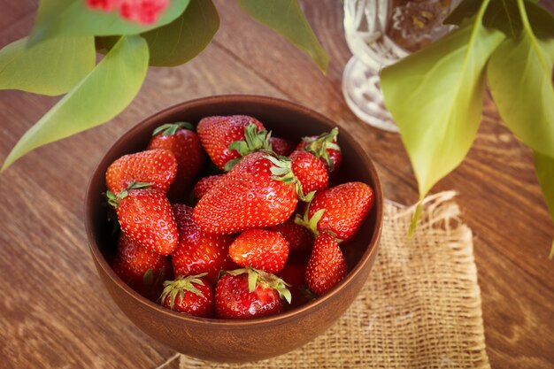 Strawberries in a bowl on wooden table