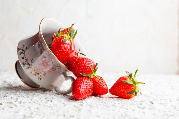 Strawberries in a coffee cup on a white textured background. side view. space for text