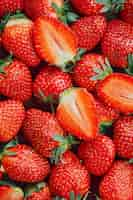 Free photo strawberries cut in half and whole berries ripe berries top view background of ripe strawberries delicious natural dessert