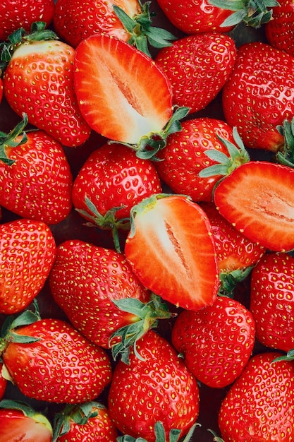 딸기는 반으로 자르고 전체 열매는 잘 익은 딸기 위쪽 전망 잘 익은 딸기 맛있는 천연 디저트의 배경