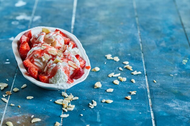 Strawberries vanilla ice-cream with sprinkles in the white plate 