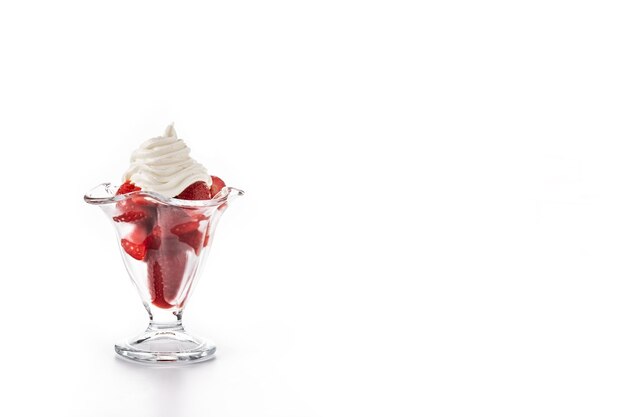 Strawberries and whipped cream in ice cream glass isolated on white background