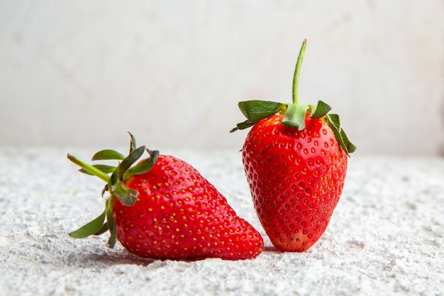 Strawberries on a white textured background. side view.