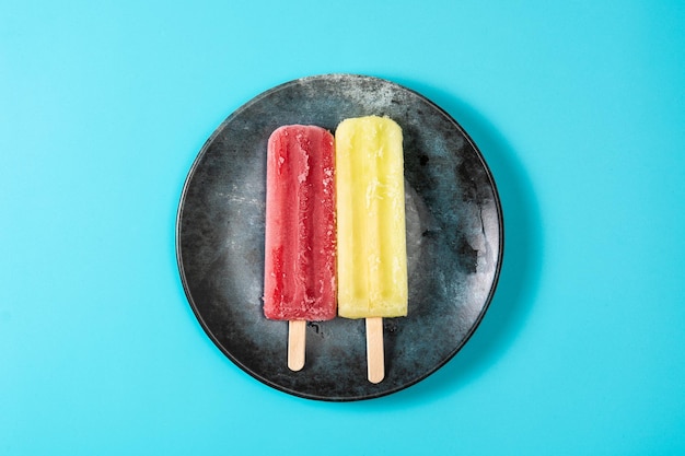 Бесплатное фото Фруктовое мороженое с клубникой и лимоном на синем фоне