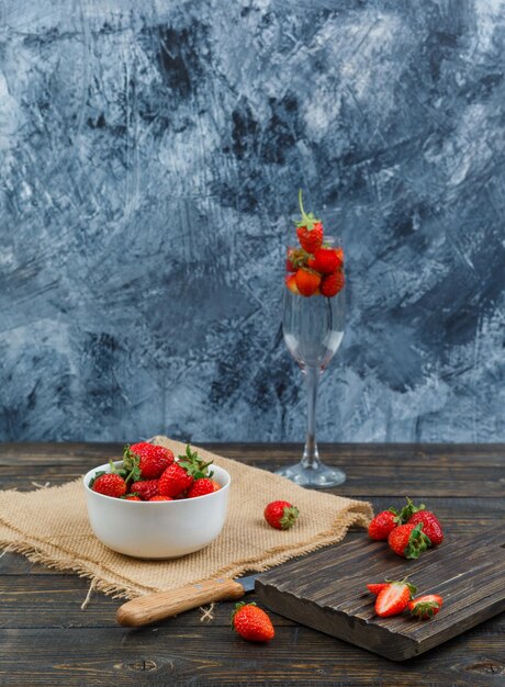 Strawberry in a bowl with wooden board