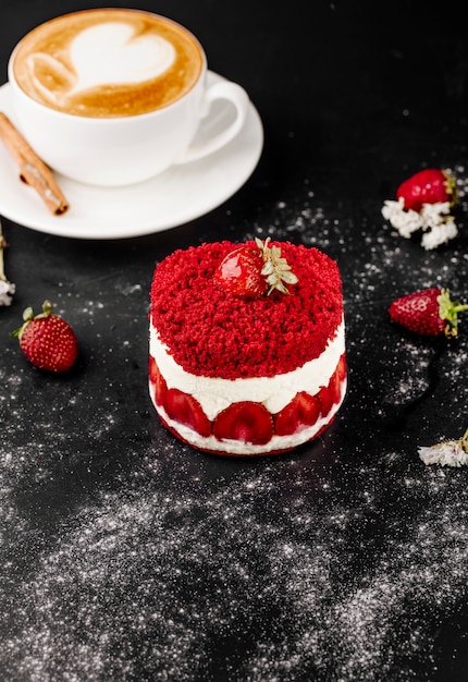 Torta alla fragola e tazza di cappuccino sul tavolo