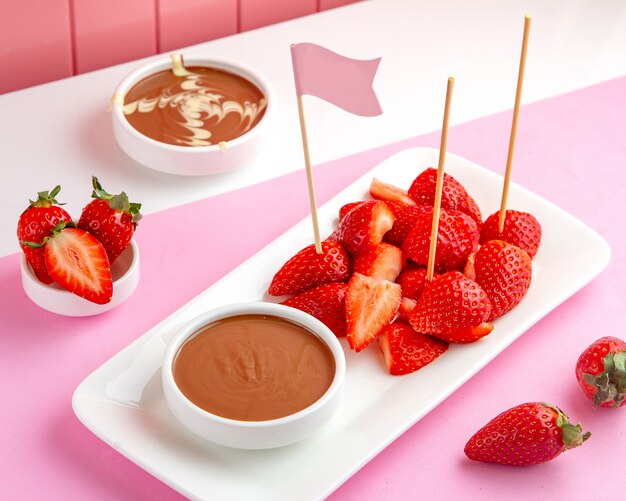 strawberry chocolate fondue with melted chocolate and strawberry on table