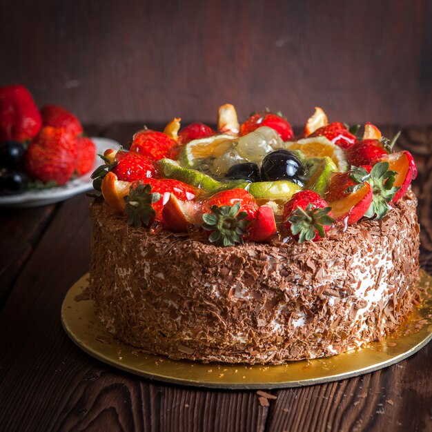 Strawberry, chocolate fruit cake and fresh strawberry on wooden table