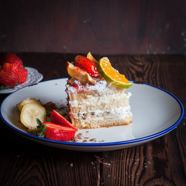 Strawberry, chocolate fruit cake in plate on wooden table