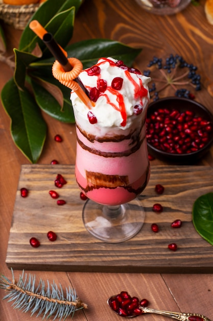 Strawberry, cream mousse tiramisu with granate seeds in glass. On wooden table 