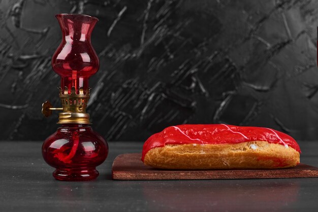 Strawberry eclair on a wooden board.