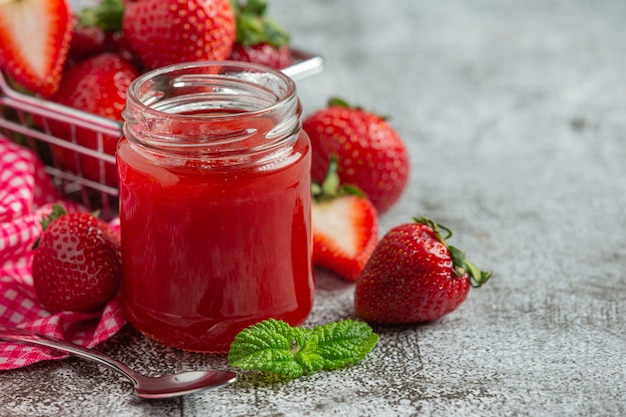 Foto gratuita marmellata di fragole sul vecchio sfondo scuro