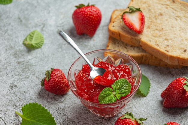 Strawberry jam on old dark background