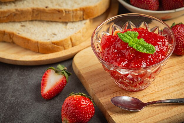 Strawberry jam on old dark background