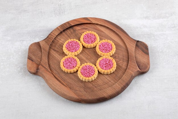 Strawberry jelly biscuits on a board, on the marble table. 