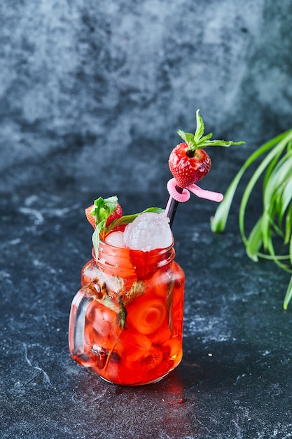 Foto gratuita limonata alla fragola con ghiaccio, menta paglia nella superficie scura