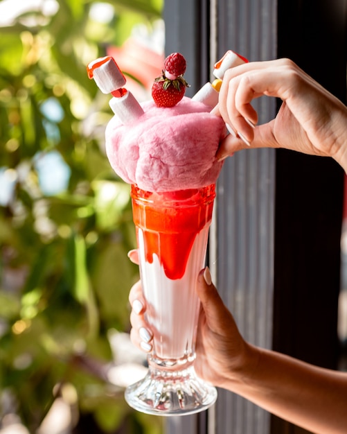 Foto gratuita frappè alla fragola guarnito con marshmallow di cotone dolce e fragole