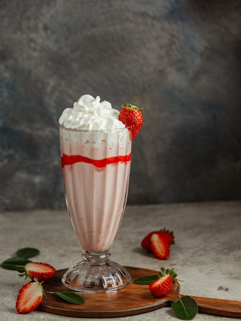 Strawberry milkshake with whipped cream and strawberries