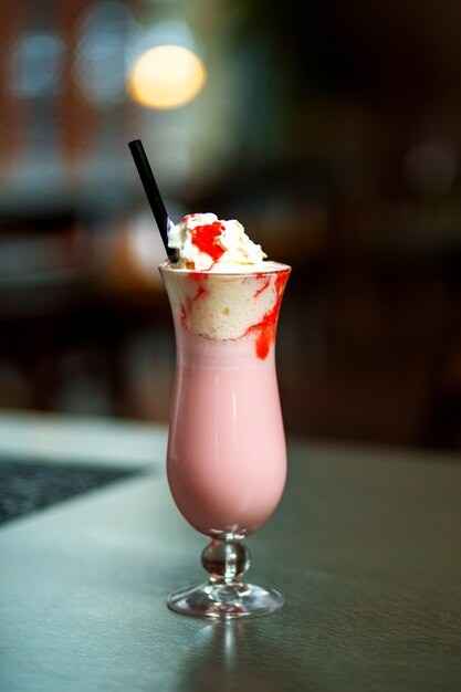 Strawberry milkshake with whipped cream and strawberry syrup