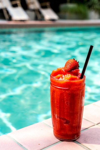 Free photo strawberry smoothie by the swimming pool