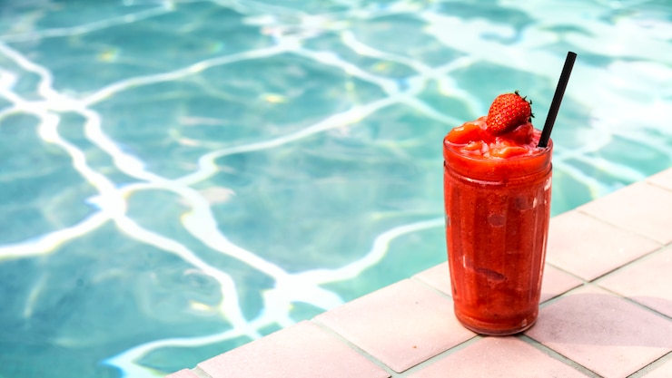 Free Photo strawberry smoothie by the swimming pool