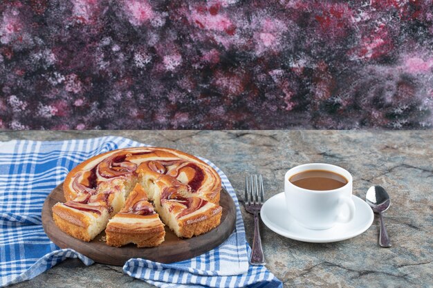 Strawberry syrup pie served with a cup of tea.