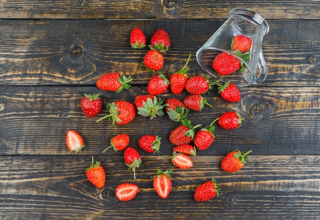 Strawberry with cup on wooden surface