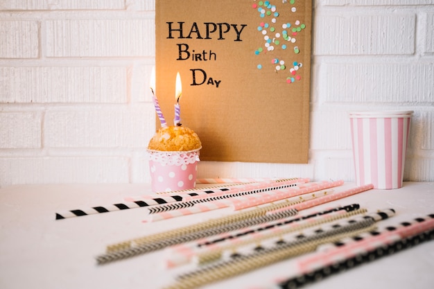 Free photo straws near birthday greeting and cupcake