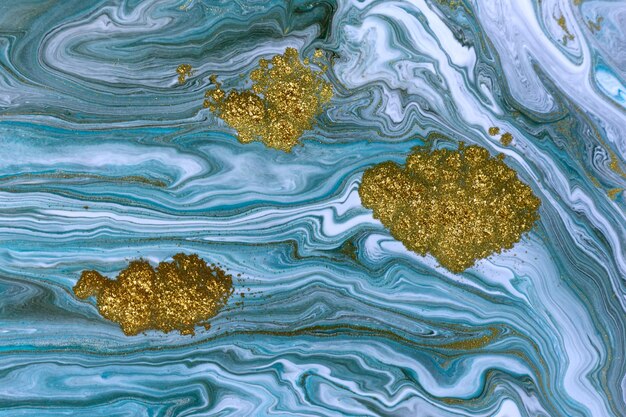 Потоки жидких синих белых и золотых чернил завивают волны жидкой бирюзы и золотой жидкой краски