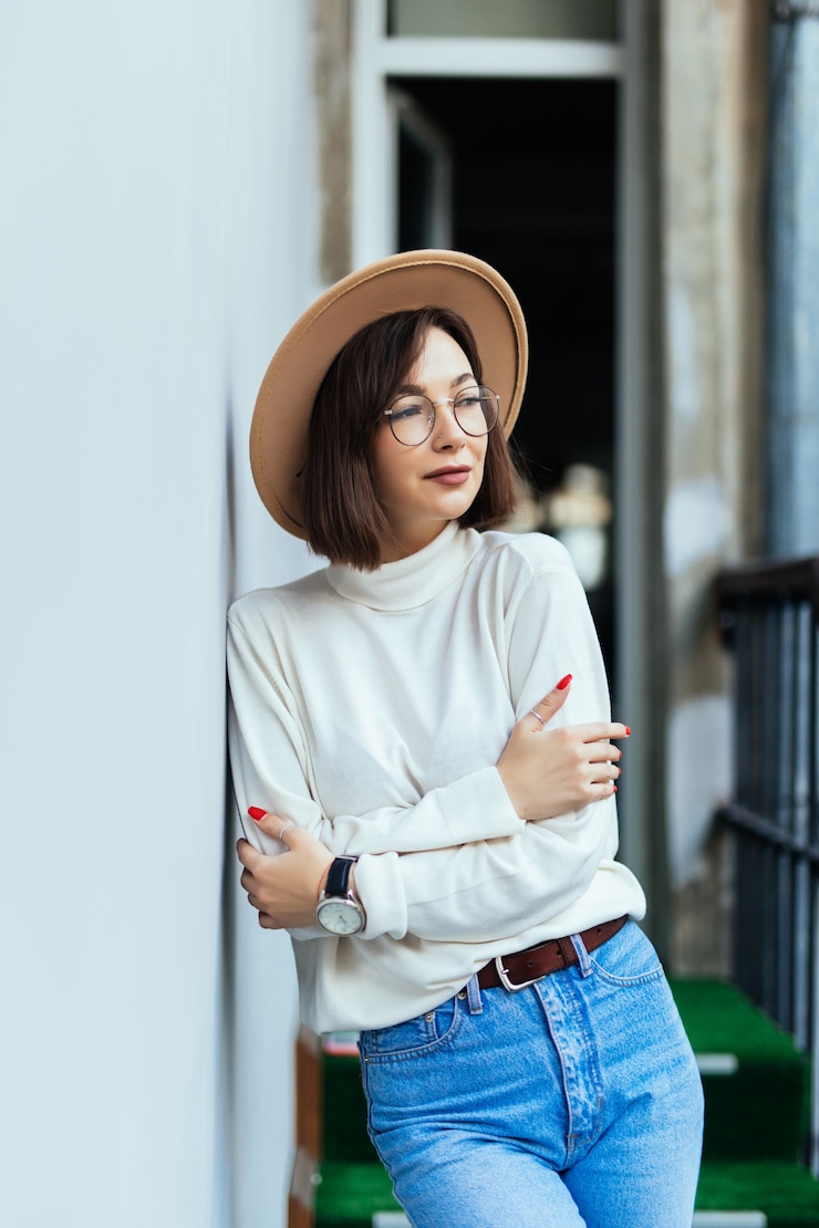 Free Photo street fashion woman wearing hat blue jeans wide hat transperent glasses on balcony