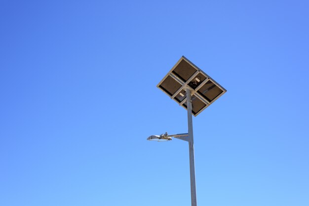 青い空の背景にソーラーパネルと街灯。グリーンエネルギー。