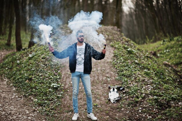 Street style arab man in eyeglasses hold hand flare with red and blue smoke grenade bomb