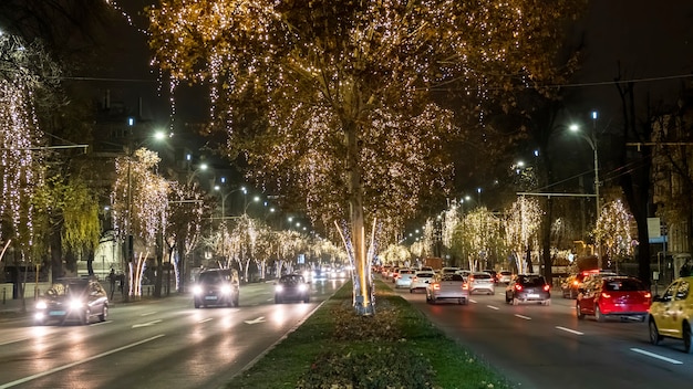 夜の街の街並み、道路を移動する車、ルーマニアのブカレストでのたくさんのクリスマスイルミネーション