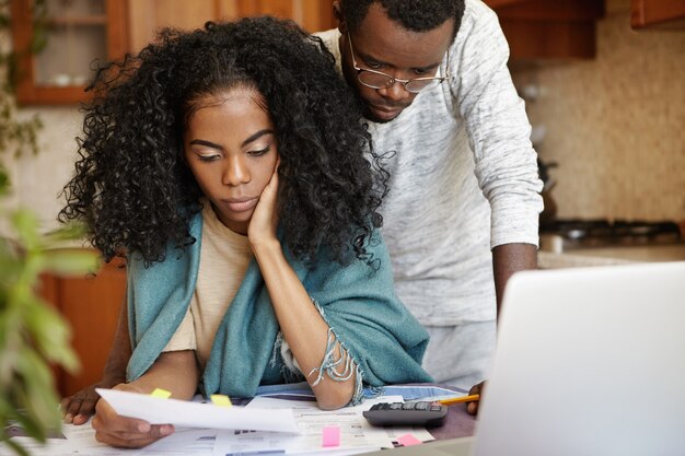 Stressed African couple having many debts trying to cut their domestic expenses to save money