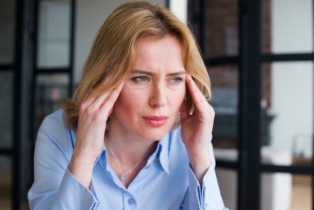 Stressed business woman holding head 