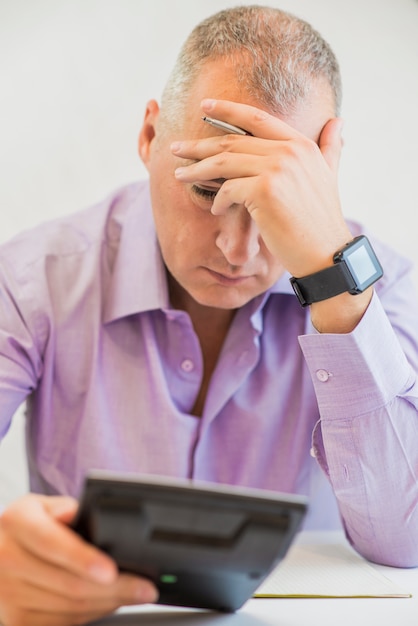 Free photo stressed businessman with head in hands in his office