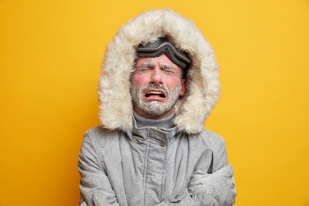ストレスのたまった冷たい男の絶望からの叫びは、霜で覆われた凍った顔が灰色のジャケットを着ている表情を不快にしています。