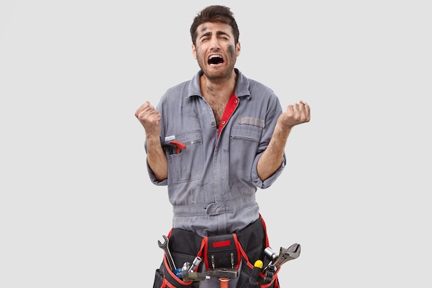 stressed handyman posing against the white wall