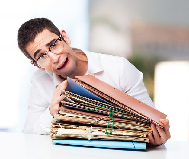 Stressed man looking at a pile of papers