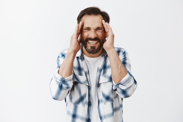 Stressed-out bearded mature man posing