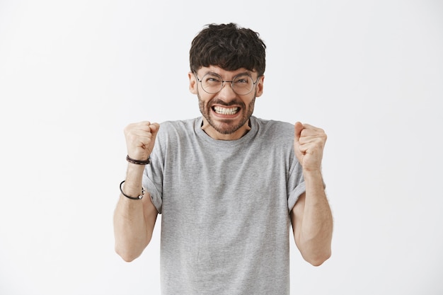 Free photo stressed-out handsome guy posing against the white wall