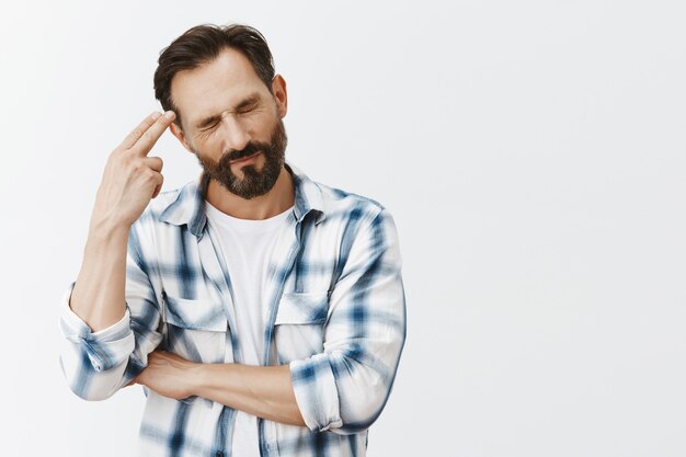 Stressed-out and tired bearded mature man posing