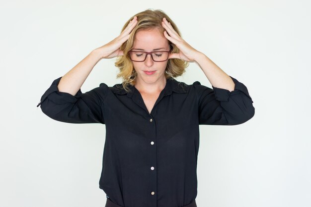 Stressed pretty young woman touching head